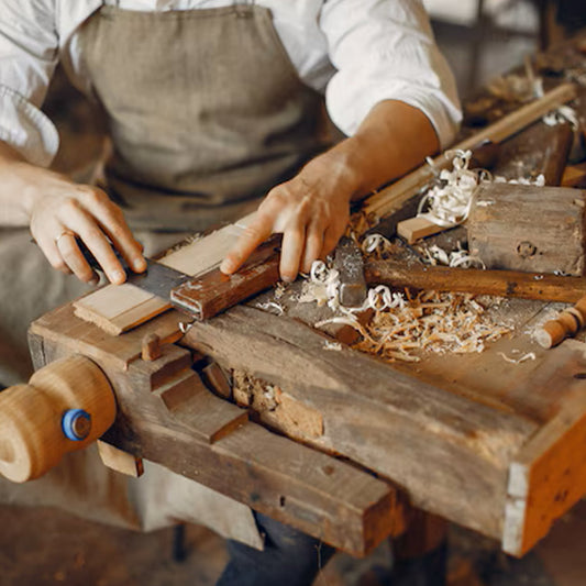 Hombre en su banco de trabajo restaurando